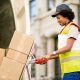 happy african american deliverer with hand truck unloading packages from van 80x80